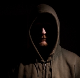 man wearing hood in dark
