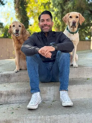 A person sitting on stairs with two dogs 